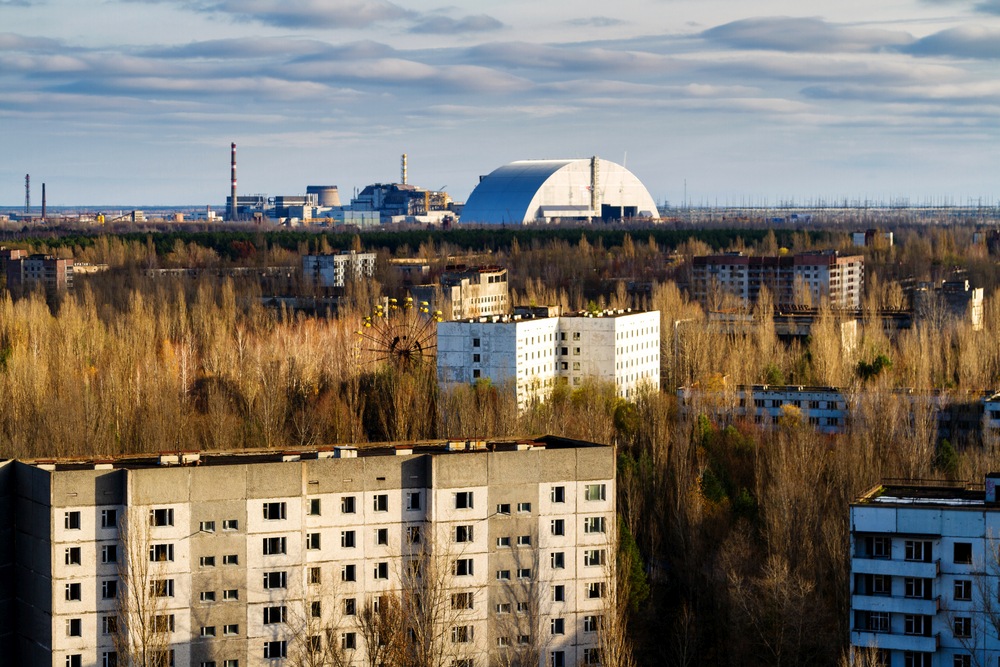 Blick aus der verlassenen Stadt Pripyat zum AKW Tschernobyl mit dem riesigen &quot;Sarkopharg&quot;, der den zerstörten Reaktor für 100 Jahre abschirmen soll. (Bild: kefirm)